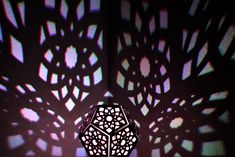 an intricately designed lamp casts shadows on the wall