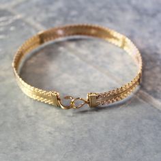 "A bold, substantial bracelet handcrafted with ten strands of 14kt gold filled wire in a classic wire-wrap style. Three strands of twist wire on each side, flanking four strands of plain square wire in the middle. Dress it up or down--it's definitely a wear-with everything accessory! Also stackable with so many of my other bracelet styles. There's nothing like an armful of affordable gorgeousness to make you feel great! The built-in hook and eye-type clasp is easy to get on and off. This bracele Adjustable Handwoven Bracelet Jewelry, Adjustable Handwoven Bracelet, Handwoven Cuff Bangle Bracelet As Gift, Handwoven Bangle Cuff Bracelet As Gift, Handwoven Adjustable Bracelet, Artisan Wire Wrapped Adjustable Bracelets, Adjustable Hand-strung Bangle Jewelry, Adjustable Multi-strand Chain Bracelet Gift, Artisan Hand Wrapped Bangle Bracelets