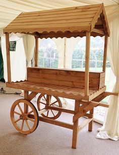 a wooden cart with a canopy on top in a room filled with white drapes