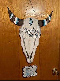 a wooden door with a cow's skull and name on it