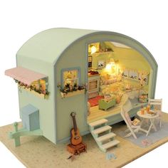 a doll house with furniture and accessories in the interior, including a bed, stairs, table, and chairs