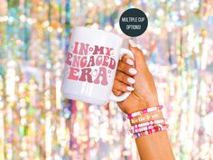 a woman's hand holding a coffee mug with the words i am my engaged err on it