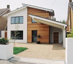 a white house with wooden sidings and an attached patio area in front of it