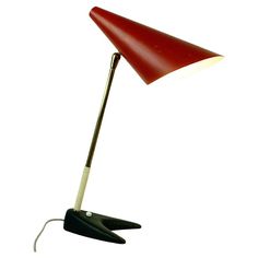 a red and white desk lamp with an upside down light on it's side