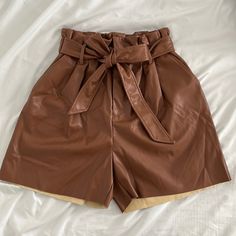 Never Been Worn! New Leather Shorts, Super Cute. Shell: 100% Polyester, Coating: 100% Polyurethane Zipper, Button And Tie Brown Faux Leather Bottoms With Belt Loops, Brown Faux Leather Bottoms For Spring, Brown Paperbag Waist Bottoms For Work, Brown Leather Short Bottoms, Chic Leather Bottoms With Button Closure, Brown High Waist Shorts With Belt Loops, High Waist Brown Shorts With Belt Loops, Brown Leather Summer Bottoms, Brown Faux Leather Shorts For Night Out