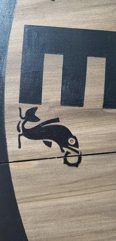 a close up of a wooden sign with an animal on it's back side