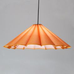 an orange and white lamp hanging from a ceiling