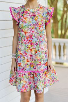 Say hello to this colorful floral babydoll dress with its charming rickrack detailing! Bursting with stunning colors, this dress is sure to brighten your day. The ruffled cap sleeves add a touch of femininity, making it perfect for any occasion. Pair it with sneakers for a fun day out or dress it up with heels for a chic, sophisticated look! Round neckline Button keyhole back Ruffled cap sleeves Colorful floral print Rickrack detailing Babydoll cut No stretch Baileigh is wearing the small. Multicolor Flutter Sleeve Dress With Ruffle Hem, Multicolor Summer Dress With Ruffle Sleeves, Multicolor Ruffle Sleeve Summer Dress, Multicolor Ruffle Sleeve Dress For Vacation, Summer Floral Dress With Flutter Sleeves And Ruffles, Multicolor Flutter Sleeve Dress With Ruffles, Multicolor Floral Dress With Ruffles And Flutter Sleeves, Multicolor Floral Dress With Flutter Sleeves And Ruffles, Multicolor Dresses With Ruffles And Flutter Sleeves