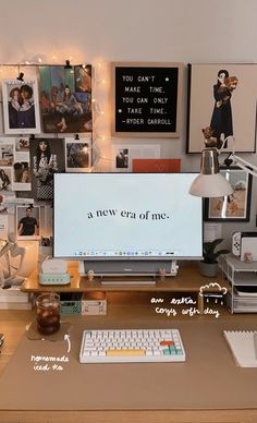 a desk with a computer, keyboard and various pictures on the wall above it that says a new era of me