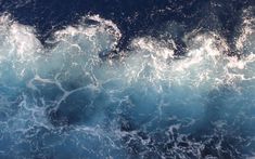 the water is blue and white with small waves on it's sides, as seen from above