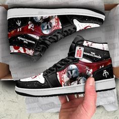 a hand is holding up a pair of shoes with the star wars theme on them