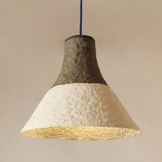 a white and brown light hanging from a ceiling fixture with a blue cord attached to it