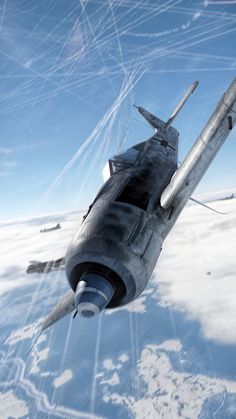 an airplane is flying through the air over some snow covered ground and clouds in the background