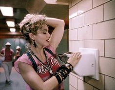 a woman in a pink shirt is using a white light switch