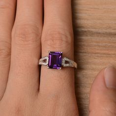 It is a natural amethyst ring. The main stone is 7 mm* 9 mm emerald cut.weight about 2.21 carats. The basic metal is sterling silver and plated with rhodium. To change the metal to a solid gold (white/rose) or platinum is also available, please ask for a quotation if you want. You can also go to my shop Home for more elegant rings: https://www.etsy.com/shop/godjewelry?ref=hdr_shop_menu Amethyst is February birthstone More amethyst rings: https://www.etsy.com/shop/godjewelry?ref=seller-platform-m Amethyst Ring With Rectangular Purple Stone For Anniversary, Purple Amethyst Ring With Rectangular Stone For Anniversary, Elegant Asscher Cut Purple Ring, Elegant Purple Asscher-cut Ring, Elegant Purple Asscher Cut Ring, Classic Sterling Silver Amethyst Ring With Emerald Cut, Emerald-cut Amethyst Birthstone Promise Ring, Classic Emerald Cut Amethyst Ring In Sterling Silver, Emerald Cut Amethyst Birthstone Promise Ring