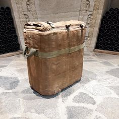 a large brown bag sitting on top of a stone floor