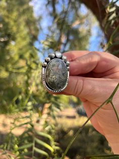 This moss agate gemstone inspired the Everglades Ring design.  The agate features green plumes that create depth and dimension at every angle. The ring also features a mother of pearl and 6 hand formed silver ball elements.  The ring features a straight ring shank in a size 8.  The ring will be packaged in a black gift box perfect for storing or gifting! Bohemian Agate Rings With Natural Stones, Bohemian Rings With Natural Agate Stones, Handmade Silver Rings With Moss Agate, Moss Agate Ring With Natural Stones, Handmade Silver Moss Agate Rings, Bohemian Agate Ring With Large Stone, Bohemian Moss Agate Jewelry, Bohemian Moss Agate Gemstone Jewelry, Handmade Oval Moss Agate Ring