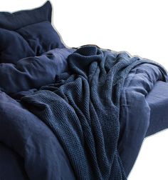 an unmade bed with blue sheets and pillows on top of it, against a white background