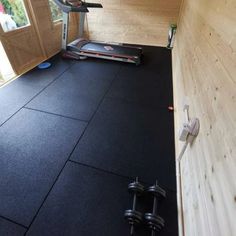 there is a treadmill on the floor in front of a door and some exercise equipment