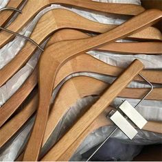 several wooden clothes hangers are stacked on top of each other