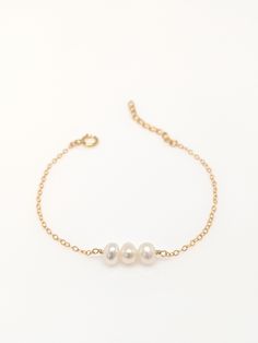 "Our gift to you 10% off your first purchase. Details here - http:/eepurl.com/dpVPBz You have found the perfect dainty pearl bracelet. Available with 1, 2 or 3 pearls. Personalize the number of pearls with your wishes, goals, children etc. Perfect for that special occasion yet simple enough for every day wear. You and your loved one will adore this meaningful gift. DETAILS 14 k fill or Sterling Silver. Choose 1, 2 or 3 pearls. Each fresh water pearl is unique, meaning the size and shape may vary 3 Pearl Bracelet, Elegant Hypoallergenic Name Bracelet With Round Beads, Elegant Gold Bracelet For Wedding And Mother's Day, Pearl Charm Bracelet For Wedding, Dainty Pearl Bracelets For Anniversary, Elegant Charm Bangle Bracelet For Mother's Day, Elegant Pearl Bracelet With Extender As Gift, Elegant Pearl Bracelet With Extender For Gift, Delicate Pearl Gold Bracelet For Gift