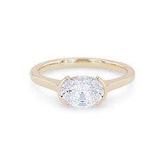 a yellow gold ring with a round cut diamond in the center, on a white background