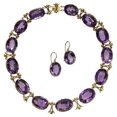 An antique amethyst and gold riviére necklace and earrings suite, with large, oval faceted, graduated amethysts, in open backed decorative, trefoil design, gallery strip bezel settings, with curved cross and ball links between the amethysts, with a gold box and tongue clasp, with matching drop earrings, on gold wires, circa 1880. Estimated total weight of amethysts in the necklace 259.99 carats and in the earrings 28.22 carats. Some of the earliest examples of amethyst jewellery are seen in work Amethyst Rock, Moonstone Drop Earrings, Amethyst Set, Diamond Cluster Earrings, Antique Modern, Amethyst Gold, House Targaryen, Heart Brooch, Gold Box