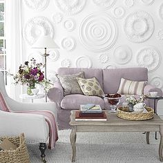 a living room filled with furniture and flowers on top of a coffee table in front of a window