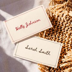 two business cards sitting on top of some woven material with the words holly johnson and sarai smith