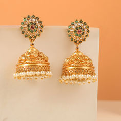 Step into the spotlight with our simply stunning antique earrings! Crafted with intricate peacock motifs in embossed antique gold-plated metal and adorned with sparkling cubic zirconia stones, these earrings are a true masterpiece. Be prepared for compliments as you showcase the perfect blend of craftsmanship and style. Ornate Jhumkas Drop Earrings With Latkans, Ornate Kundan Jhumkas, Ornate Jhumkas With Latkans Drop Earrings, Ornate Brass Jhumkas For Festive Occasions, Ornate Brass Jhumkas For Wedding, Ornate Jhumkas With Intricate Design For Diwali, Ornate Brass Jhumkas For Festive Season, Ornate Jhumkas For Diwali, Festive Ornate Brass Jhumkas