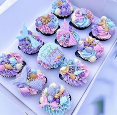 cupcakes decorated in pastel blue and purple icing with mermaid themed decorations