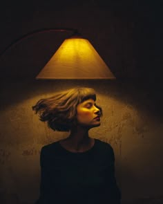 a woman standing in front of a lamp with her head turned to look like she's floating