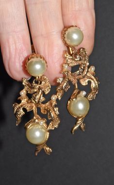 "Fancy Vintage Statement Gold Tone Leaf & Pearl Dangle Screw Back Earrings Stunning dangle gold tone metal earrings. Large faux pearls and tiny faux pearls accent the earrings. They have screw backs. These earrings are unmarked. Earrings are 2\" long x 7/8\" wide. Large pearls are 9mm round. Small pearls are 2.4mm round. Pearls are an off white color. In great pre owned condition. A little discoloration on the gold tone but they look great for their age. Thanks for looking :)" Gold Chandelier Earrings With Pearl Charm For Party, Gold Pearl Chandelier Earrings For Evenings, Gold Vintage Chandelier Earrings For Anniversary, Vintage Gold Chandelier Earrings For Anniversary, Vintage Gold Pearl Earrings, Vintage Yellow Gold Pearl Earrings For Formal Occasions, Vintage Gold Pearl Drop Earrings, Formal Gold Chandelier Earrings With Pearl Charm, Victorian Style Gold Clip-on Earrings For Party