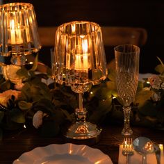 the table is set with candles, plates and silverware for an elegant dinner party