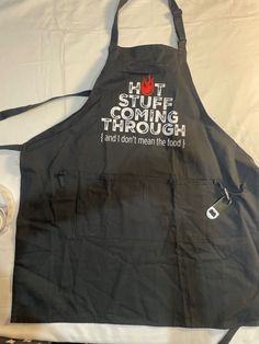 a black apron with the words hot sauce coming through and don't mean the food