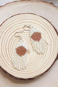 "These hand beaded earrings are made with delica seed beads in cream and pumpkin colors. Hanging from silver colored ear wires, they measure 3\" in length. Hand woven with durable high quality thread!" Cream Beaded Dangle Earrings, Cream Beaded Dangle Jewelry, White Handwoven Drop Earrings, Adjustable White Beaded Tassel Earrings, Beaded Beige Dangle Jewelry, White Handwoven Dangle Beaded Earrings, White Handwoven Beaded Dangle Earrings, Beige Beaded Dangle Jewelry, White Bohemian Tassel Earrings With Tiny Beads