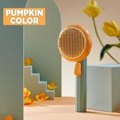 an orange hair dryer sitting on top of a table next to flowers and stairs