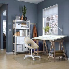 a room with a desk, chair and bookshelf next to a large window