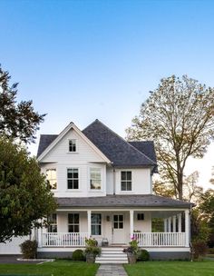 a large white house sitting on top of a lush green field