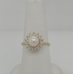 Exquisite 14k Gold Statement Ring: 7.2mm Pearl & .50ct Diamonds, Size 8.25. Discover timeless elegance with this stunning statement ring featuring a lustrous 7.2mm pearl at its center, surrounded by .50 carats of dazzling diamonds, all set in a classic basket-style design of 14k gold. Perfect for making a sophisticated statement. Elegant Pearl Ring With Round Cut Center Stone, Formal Pearl Ring With Diamond Halo Design, Elegant Pearl Ring With Center Stone For Anniversary, Classic Oval Pearl Ring With Center Stone, Classic Yellow Gold Pearl Ring With Cubic Zirconia, Classic Pearl Ring With Cubic Zirconia Center Stone, Formal Diamond Pearl Ring With Halo Design, Classic Round Pearl Ring With Halo Design, Classic Pearl Ring With Halo Design