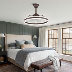 a bedroom with a large bed and two lamps hanging from the ceiling over it's headboard