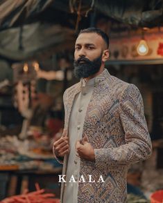 a man with a beard wearing a jacket and standing in front of an open market