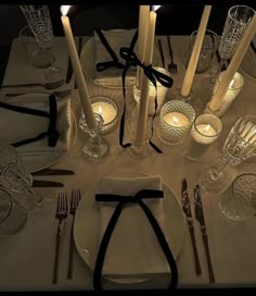 a table set with silverware and candles