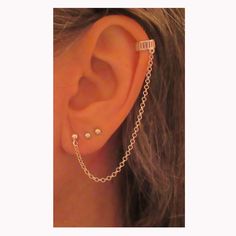 a woman wearing a chain ear cuff with pearls