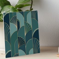 an art deco design in blue and gold on a table next to a potted plant