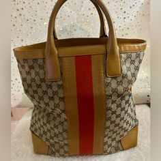 Gucci Gg Canvas Monogrammed Shopper Tote Bag Large. Tan Leather Trim, Orange/Tan Stripe Down Both Sides. Tan Leather Handles, Corners, And Bottom. All In Amazing Condition. The Only Call Out Is Rubbing On The Corners Which Is Not Major Rubbing. Look At All Pictures. Please Ask Questions, And Lmk If You Have An Offer For This Adorable Bag!! No Rips No Tares No Piping Issues Only Call Out Minor Rubbing On The Corners. The Bottom Is In Incredible Condition! Dc: 002.193.3444 13in X 15in. X 7.5in Pre-owned Beige Gucci Bag, Pre-owned Designer Brown Bags, Gucci Gold Monogram Canvas Bag, Pre-owned Gucci Bags For Shopping, Designer Pre-owned Shopping Bag, Pre-owned Brown Gucci Bag, Designer Pre-owned Bags, Pre-owned Brown Top Handle Shoulder Bag, Shopper Tote