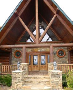 the front entrance to a log cabin with deer heads on it