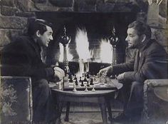 two men sitting at a table playing chess