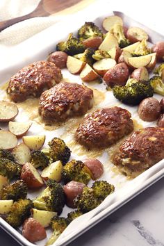 meatballs, potatoes and broccoli on a baking sheet