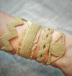 a person's arm with gold bracelets on it